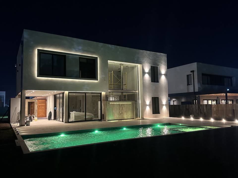 Vivienda y pileta iluminadas de noche