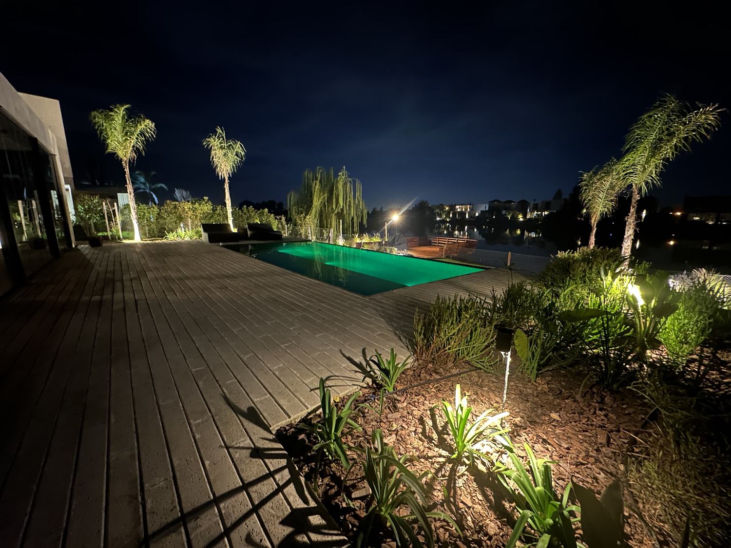 Deck y pileta iluminados frente a la laguna