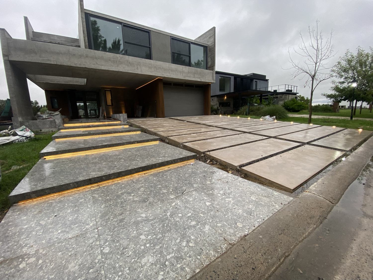 Escalones de acceso con luz lineal y balizas en el camino